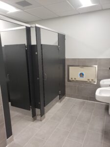 A bathroom with two stalls and a sink.