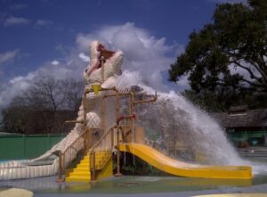 A man riding down the side of a water slide.